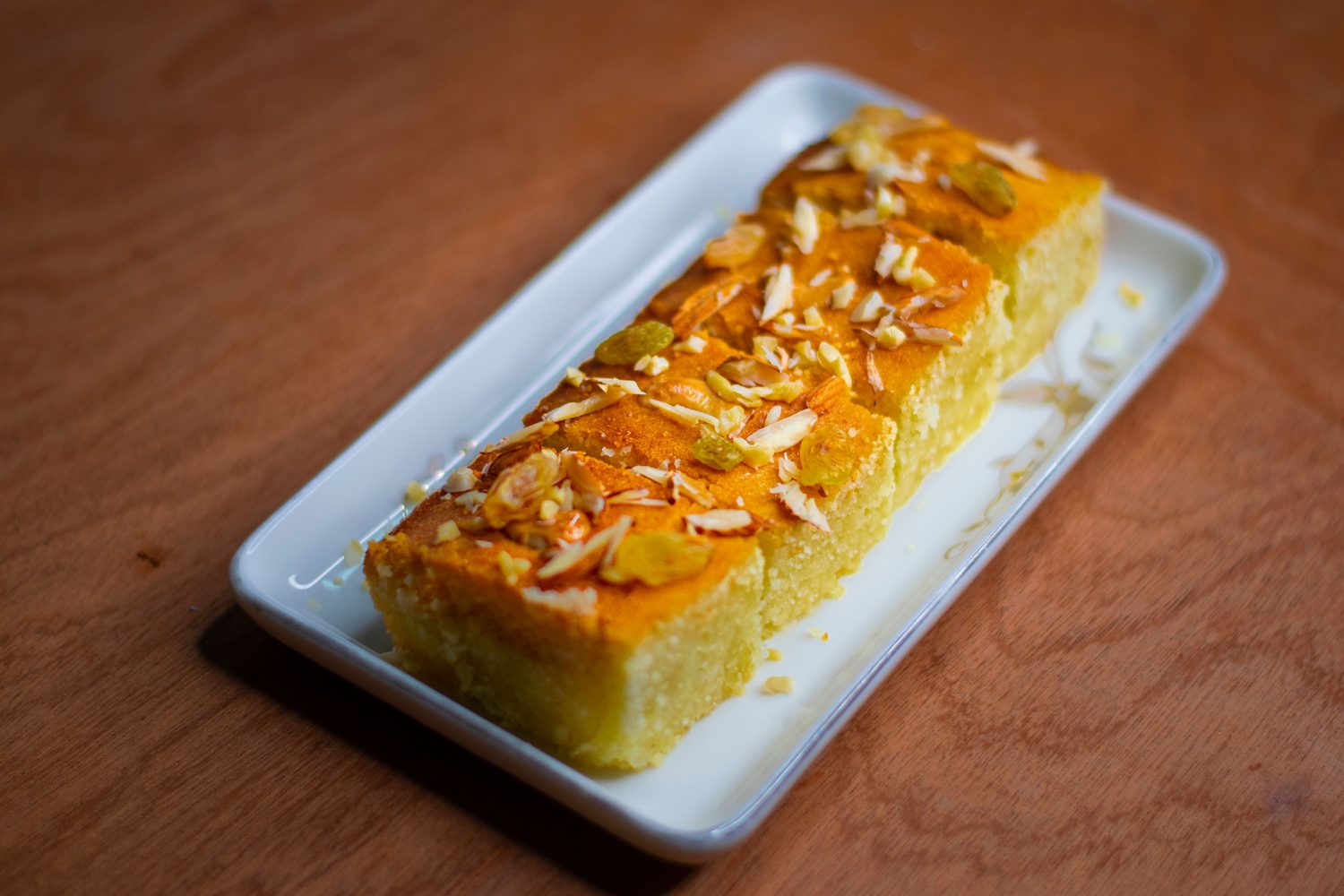 The mawa cake with almond slivers and raisins, close up on a plate